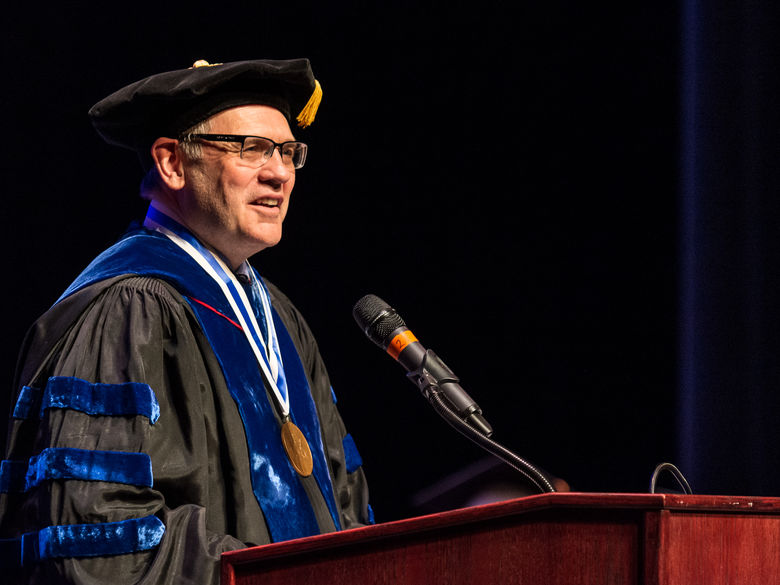 Dr. David Christiansen speaks from the podium during a commencement ceremony