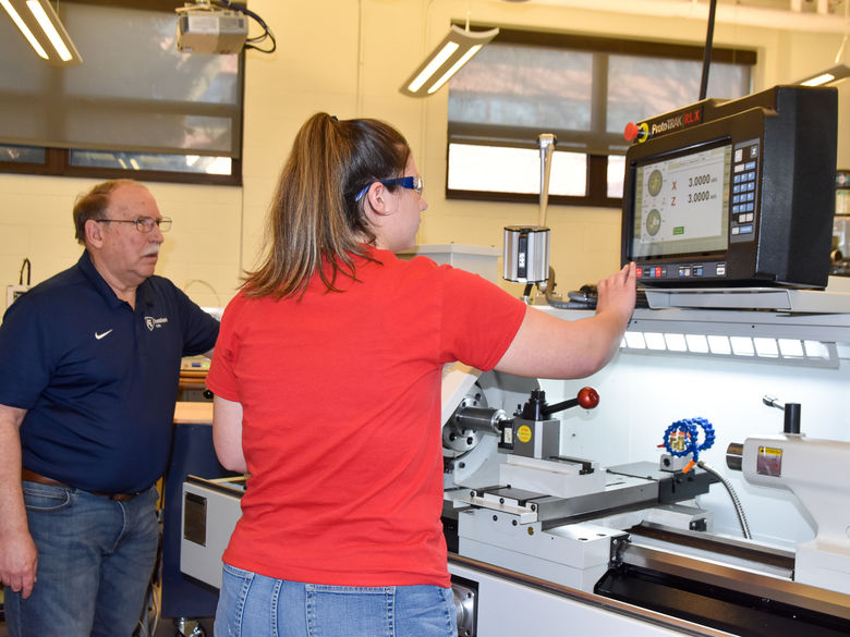 Students working with a lathe in an engineering lab.