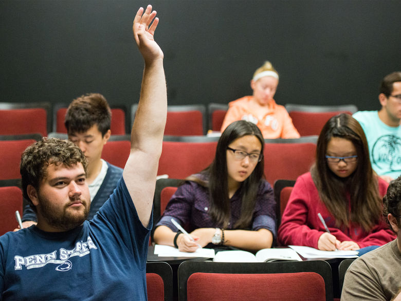 Student raising his hand during a class.