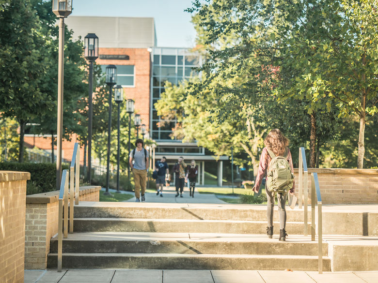 Students walking on the sidewalk between the Joe and Rosie Ruhl Student Community Center and the Pullo Performing Arts Center.