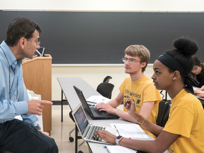 Students and a professor talk during a business class