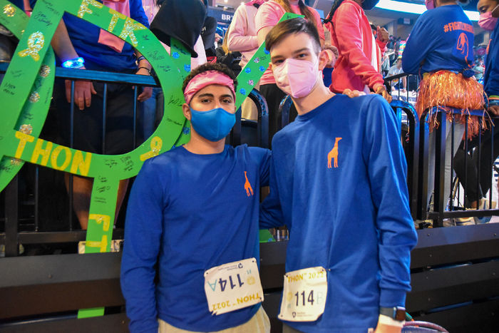 Two young men wearing long-sleeved blue shirts participate in dance marathon.