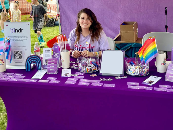 Female with long dark hair displaying items at a vendor table