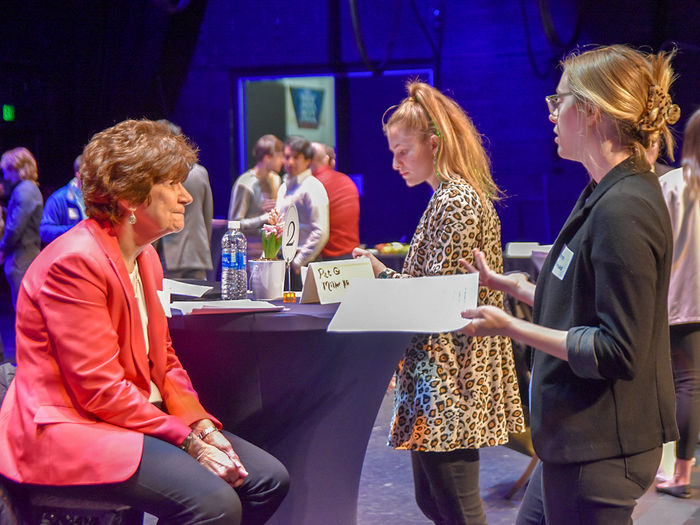 Students conversing with an industry professional at a career networking event.