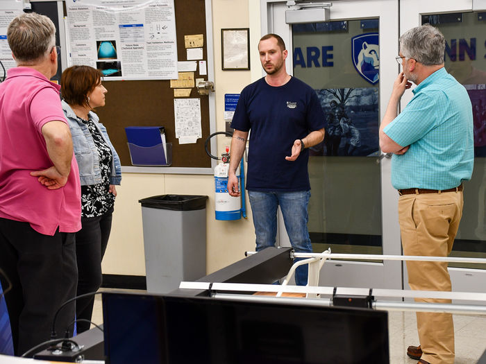 Engineering student having a discussion with faculty about a responsive light prototype.