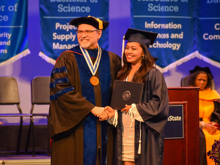 Penn State York graduate shaking Chancellor Christansen's hand during the Spring 2023 Commencement Ceremony.