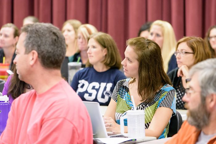 Students sitting at desks in a large classroom.