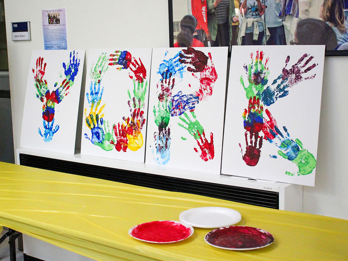 Students and faculty put their printed handprints on white canvases to collectively spell out "We Are Penn State York".