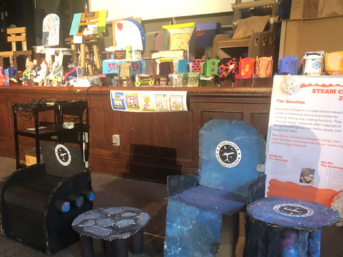 Variety of chairs and tables made from cardboard on display