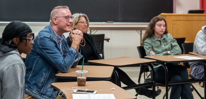 Laureate William Doan holds a conversation in an English class.