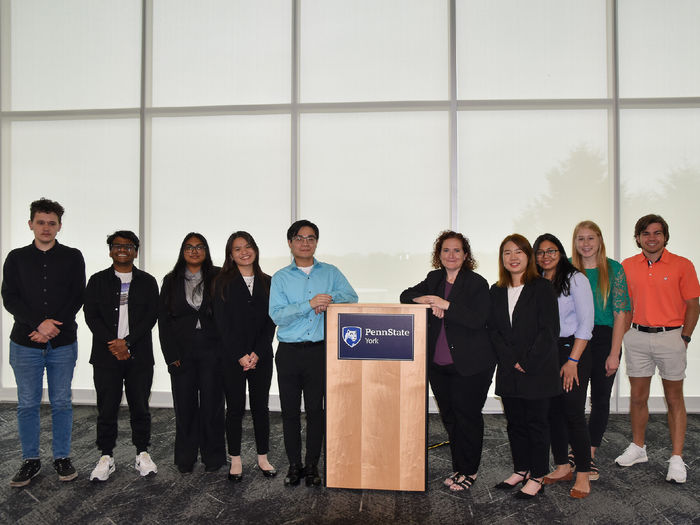 Ten students and faculty memberlined up on either side of a podium