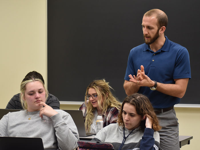 Dr. Foster providing instruction to a small group of psychology students in class.