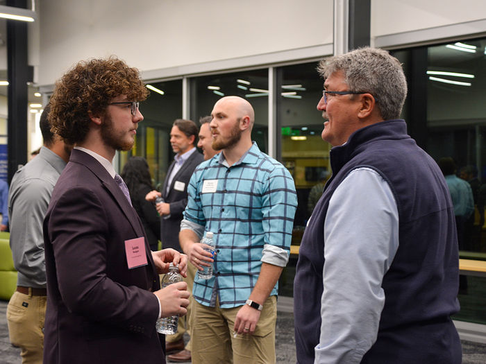 Graham student and industry professional having a conversation in Polli Hall.