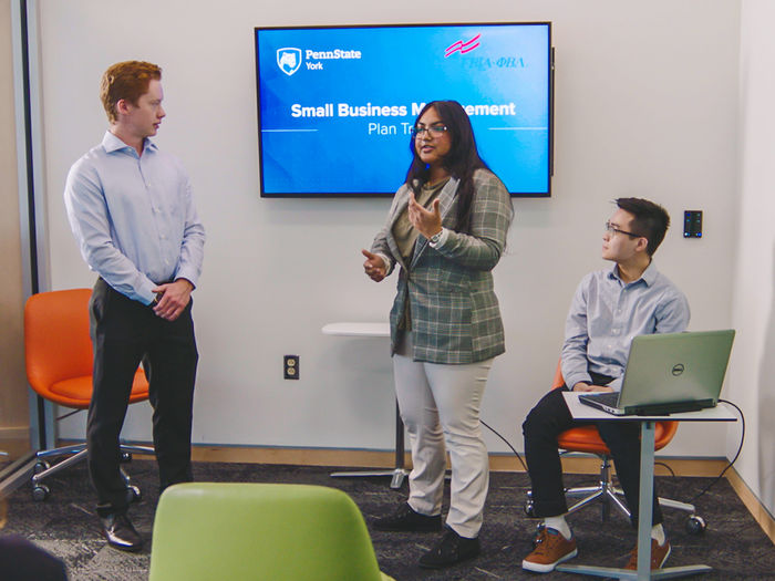 Three students giving a Small Business Management presentation.