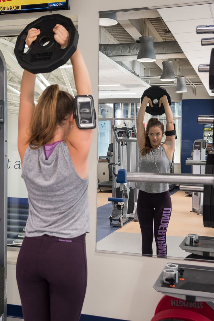 Student lifting a weight in the fitness center.