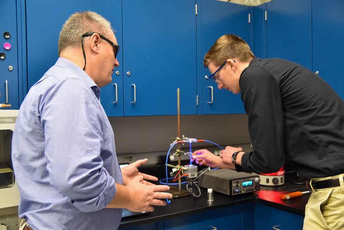 Logan Coomes (right) doing research with associate professor of chemistry Andy Landis (Left)