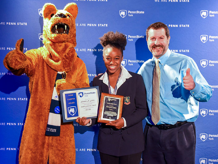 Nittany Lion character with Afican American female student and white male staff member