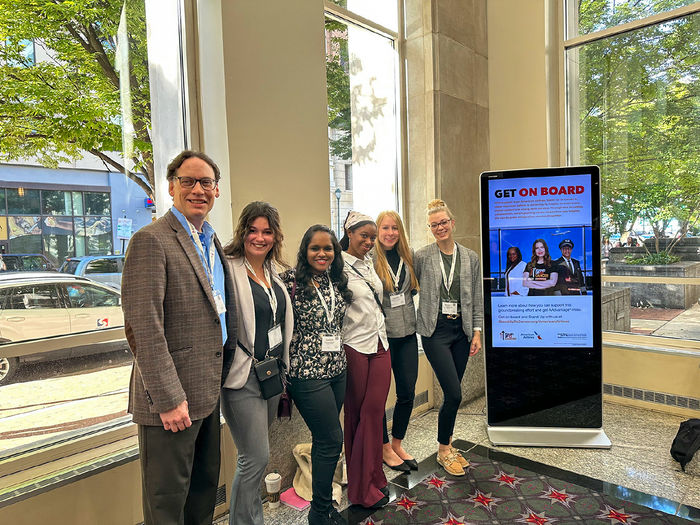 One male and five female college students pose for a picture at the women's conference in Philadelphia.