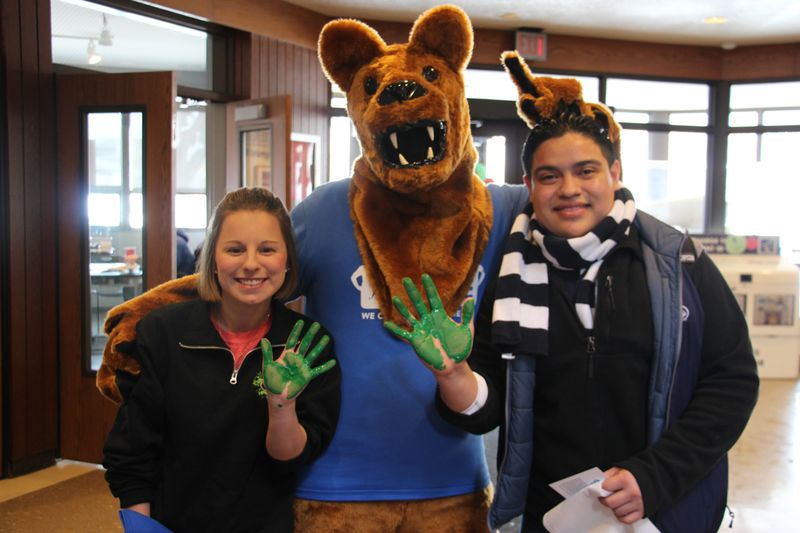 Students with their hands covered in green paint 