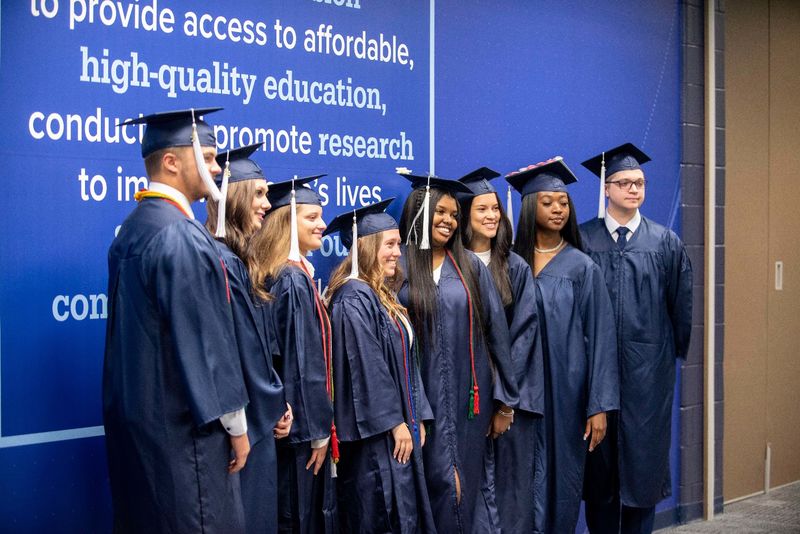 Graduating students posing in the Health and Wellness Building at Penn State Schuylkill