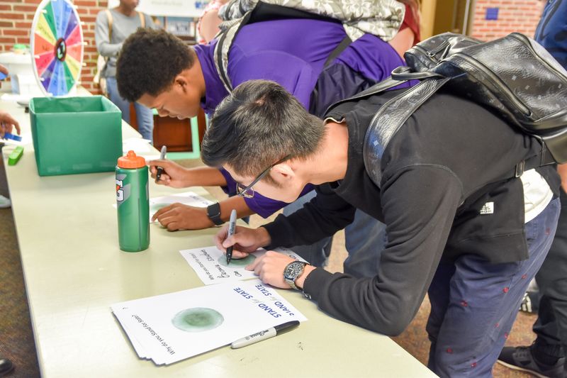 Students writing during a Stand for State event.