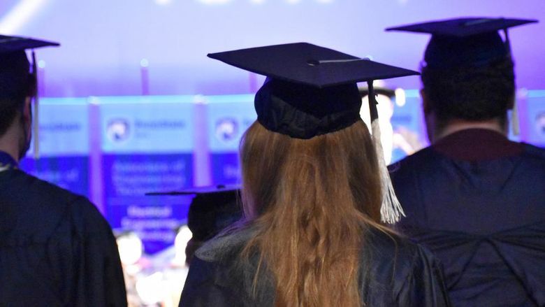 The back of male and female stduents wearing caps and gowns