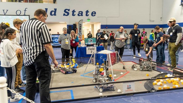 Students and adults sompete in a robotics competition