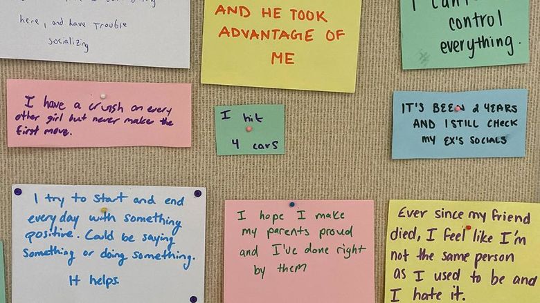 Secrets of individuals written of paper and pinned to a bullertin board