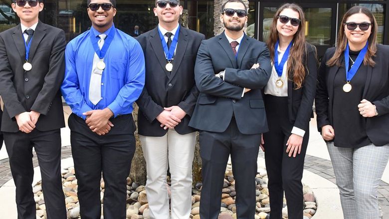 Four male and two femaile students wearing sunglasses in business attire