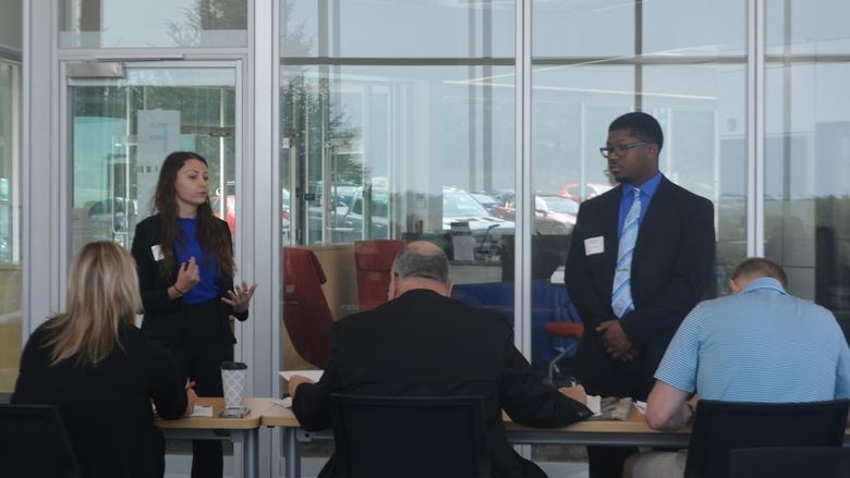 Two students present to a group of judges