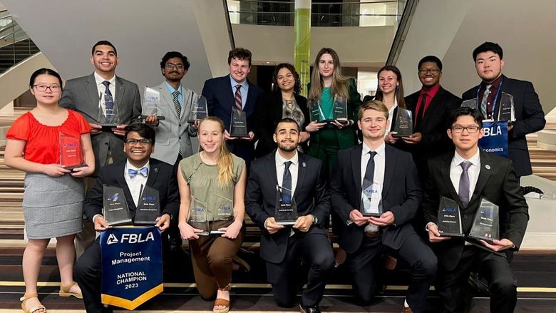 Group of young men and women holding awards.