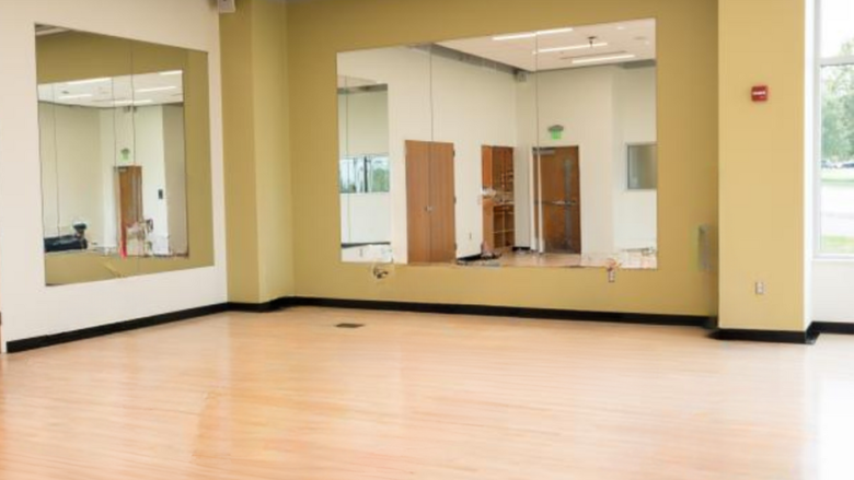 Empty room with mirrors on the walls and wooden dance floor