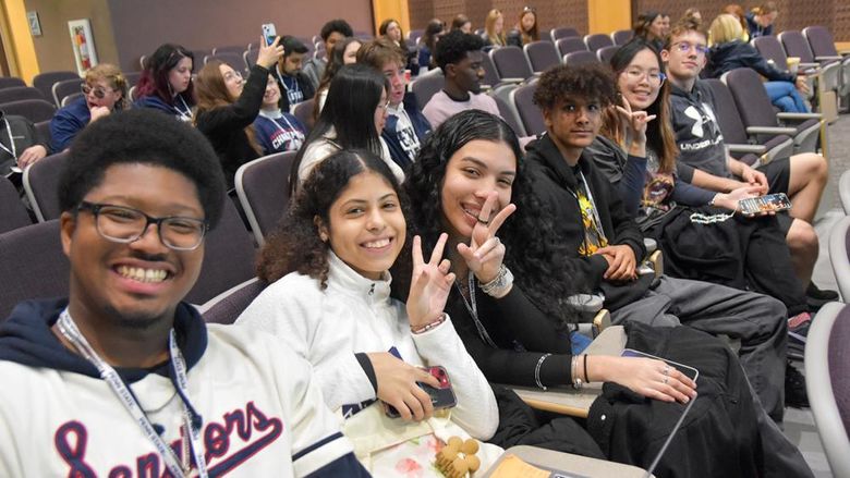 Male and female students sitting in an auditorium