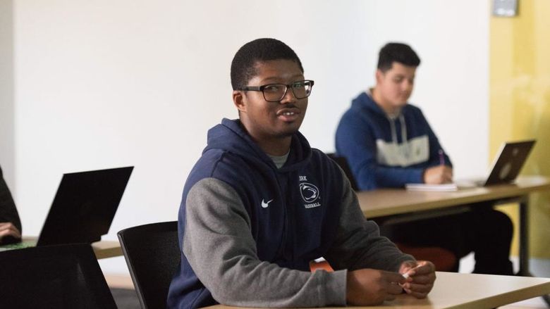 African American student and caucasian student at desks in class