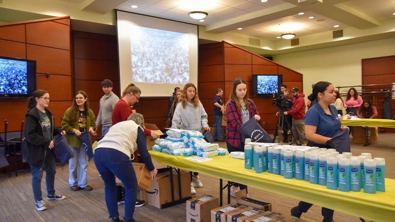 Students, faculty, and staff assembling hygiene kits for the YWCA of York