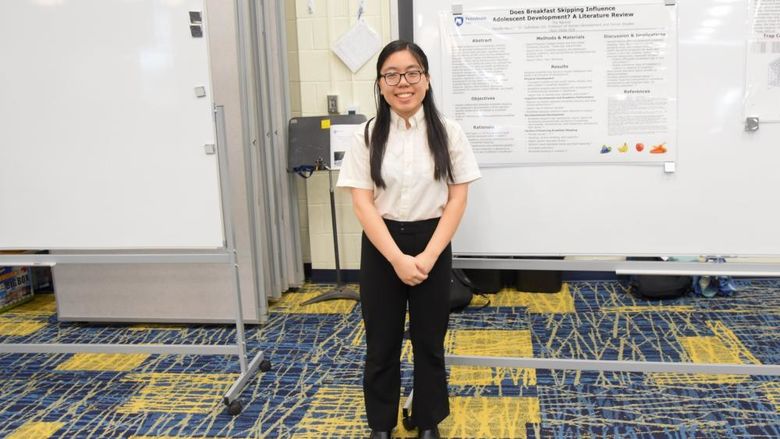 Female student standing in front of a whiteboard.