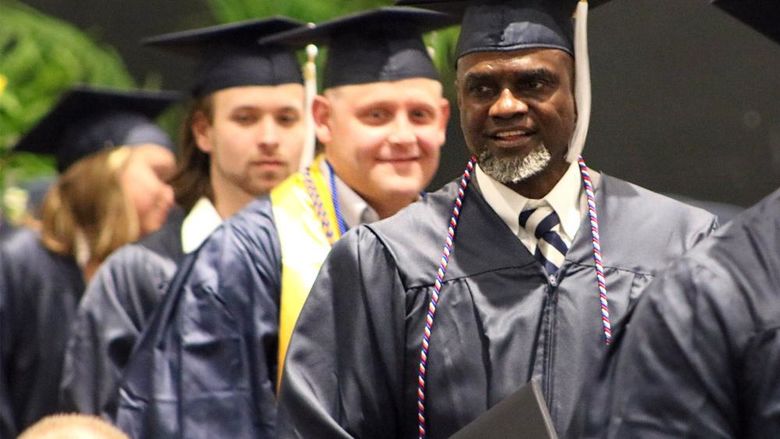 Graduates wearing caps and gowns smiling