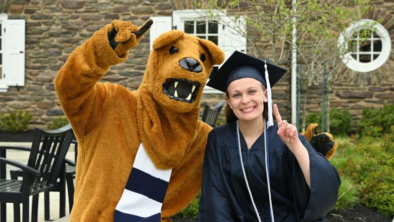 Nittany Lion mascot and female graduate outdoors