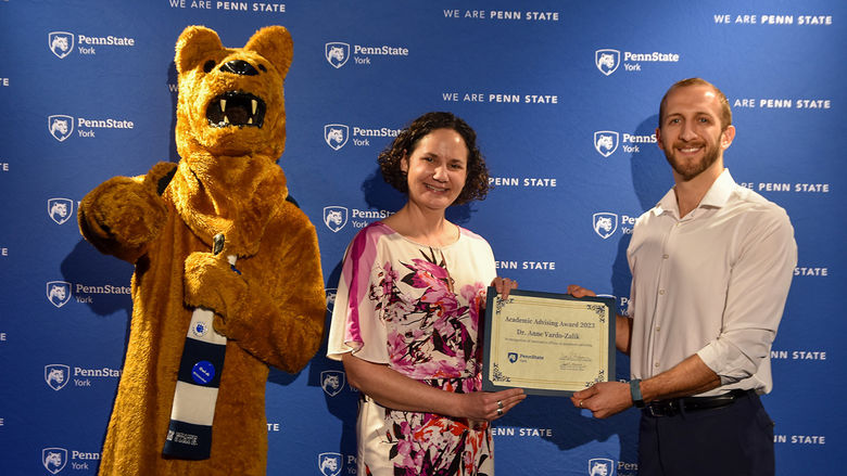 Nittany Lion characters, and a female and male fculty member hold a certificate