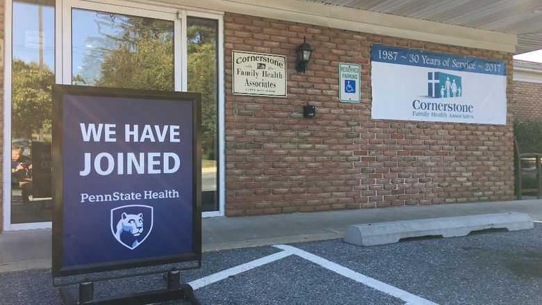 A sign reading "We have joined Penn State Health" sits in front of a brick building labeled "Cornerstone Family Health Associates."