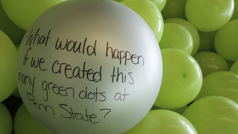 A balloon with the message "What would happen if we created this many green dots at Penn State?"