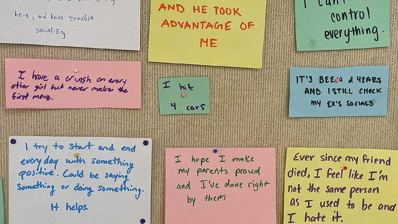 Secrets of individuals written of paper and pinned to a bullertin board