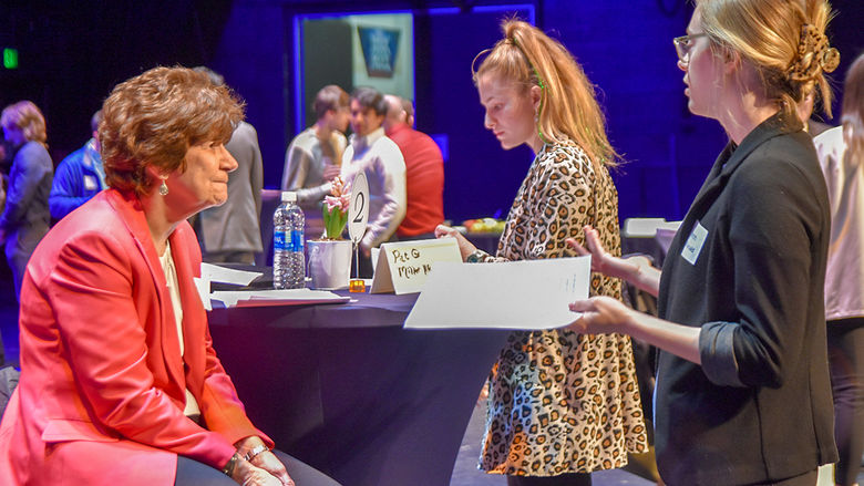 Students conversing with an industry professional at a career networking event.