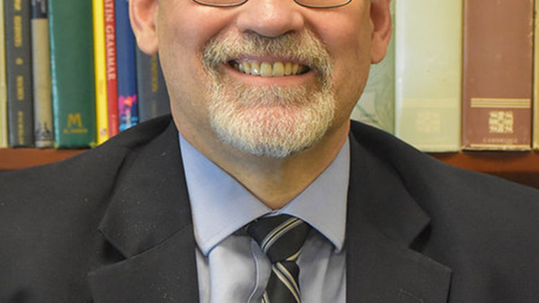 Headshot of Chancellor Christiansen standing against a bookshelf.