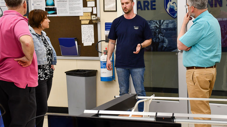 Engineering student having a discussion with faculty about a responsive light prototype.