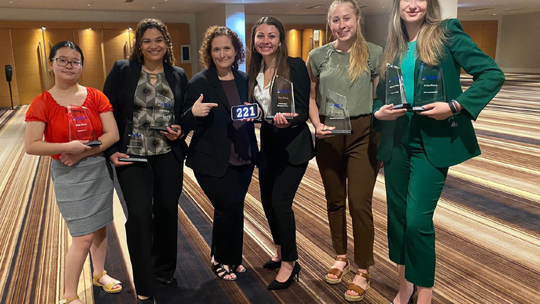 Five college students and their adviser show off their national awards.