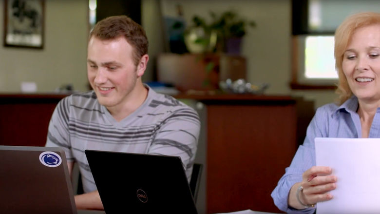 Student and adviser working at laptops