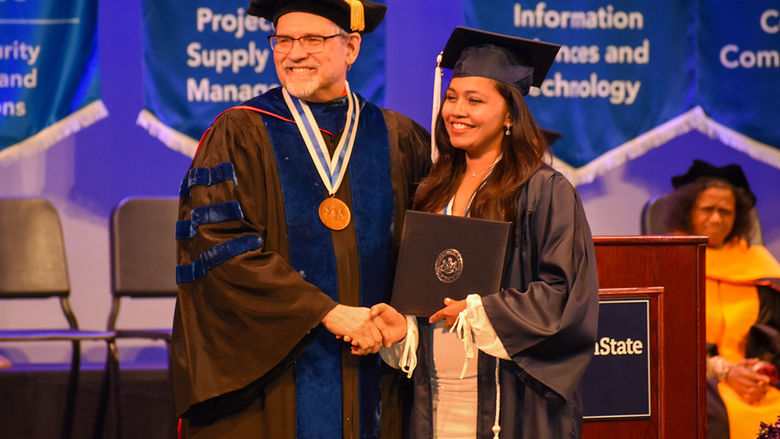 Penn State York graduate shaking Chancellor Christansen's hand during the Spring 2023 Commencement Ceremony.