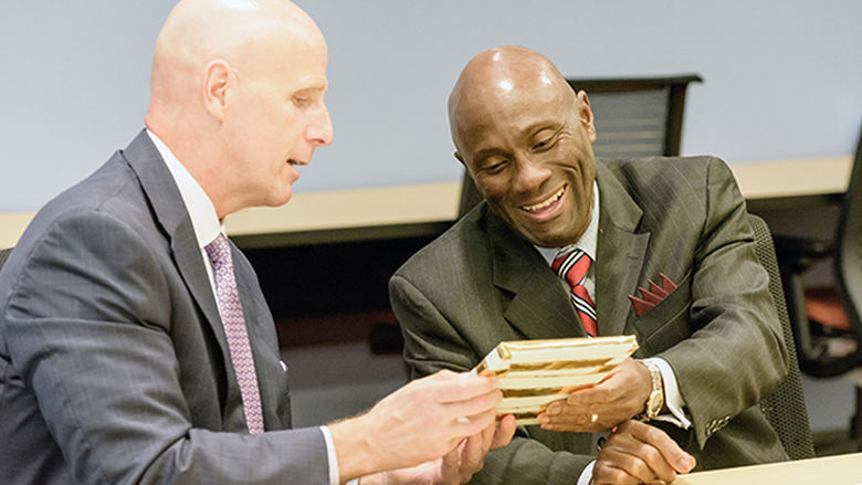 John Sygielski gives Francis Achampong a HACC picture frame as a gift.