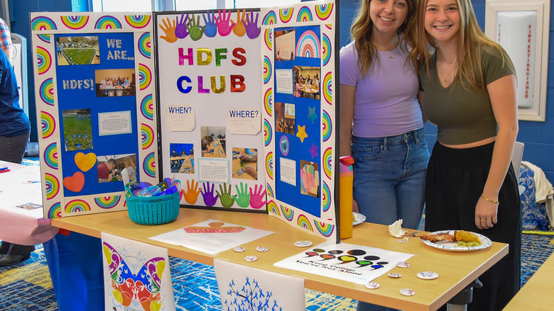 Two HDFS students recruiting new members of the HDFS Club at an involvement fair.